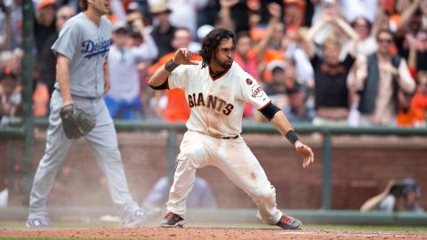 Ángel Pagán celebra tras anotar la segunda carrera de los Gigantes, ante la mirada de Clayton Kershaw.