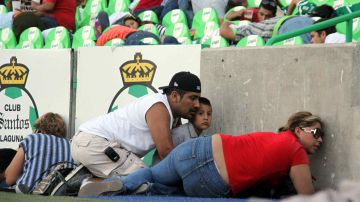Aficionados del Santos se ponen a salvo durante un tiroteo afuera del Estadio Corona en agosto de 2011. /MEXSPORT