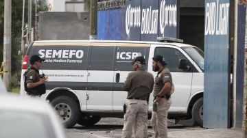 Forenses ingresan al sitio donde un grupo armado asesinó a diez personas en el municipio de García, cerca de la ciudad de Monterrey.