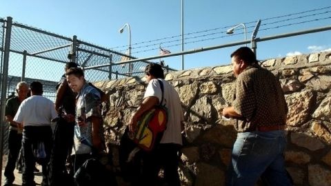 Inmigrantes deportados cruzan la frontera hacia México.