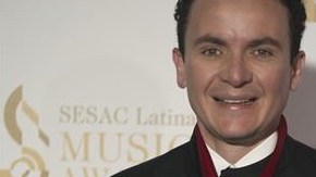El cantante colombiano Fernando Fonseca presume presea en la alfombra roja de los premios SESAC Latina.
