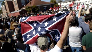 Simpatizante del Ku Klux Klan ondea una bandera confederada.