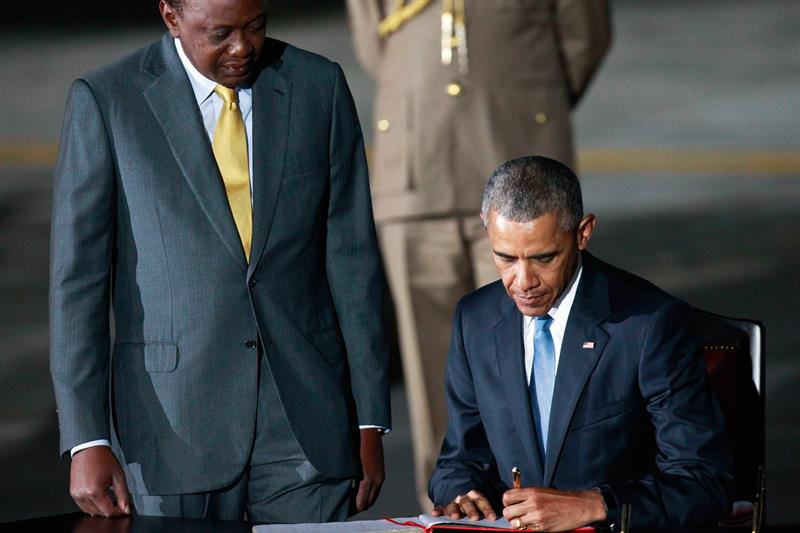 El presidente Obama firma el libro de visitantes mientras el presidente kaniano Uhuru Kenyatta lo observa.