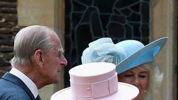 La Reina Isabel, en rosa, mira a la recién bautizada Charlotte, en brazos de su madre, Kate Middleton.
