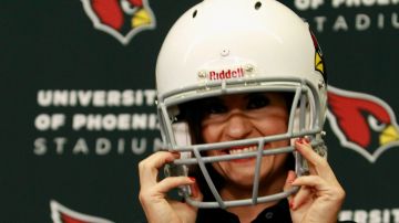 Jen Welter se pone un casco de los Cardinals de Arizona el martes luego de ser presentada como coach pasante del equipo.