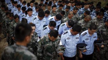 Soldados, policías y paramilitares asisten a un funeral por las víctimas de la explosión.