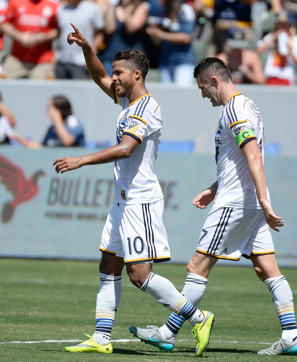 Giovani celebra su gol del domingo en compañía de Robbie Keane, con quien hizo amistad en sus días con el Tottenham de Inglaterra.