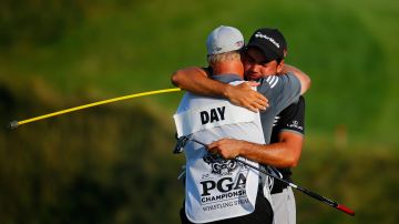 Jason Day, de Australia, no puede contener su emoción junto a su caddie Colin Swatton tras ganar el PGA Championship el domingo.