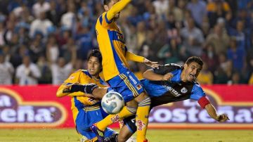 Carlos Bueno (der.) es frenado por Hugo Ayala en el juego de ida de la semifinal del Apertura 2011, celebrado ayer en La Corregidora.