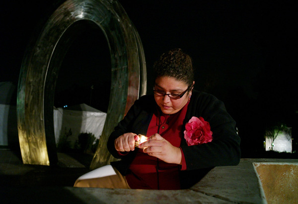 Rosy Tellez, enciende una vela en honor a su cuñado, en la ceremonia The Wall Las Memorias.