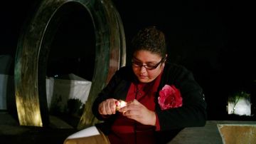 Rosy Tellez, enciende una vela en honor a su cuñado, en la ceremonia The Wall Las Memorias.