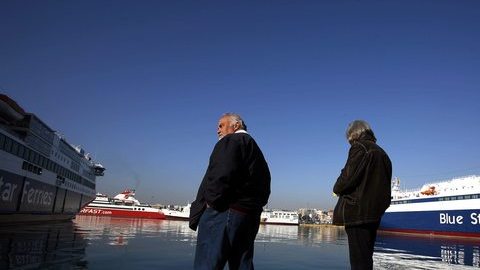Dos huelgistas esperaban la llegada de un buque en el muelle del Pireo, cerca de Atenas.