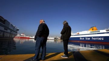 Dos huelgistas esperaban la llegada de un buque en el muelle del Pireo, cerca de Atenas.
