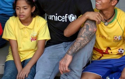 David Beckham es abrazado por niños que visitó en Manila.