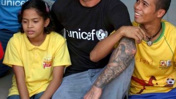 David Beckham es abrazado por niños que visitó en Manila.