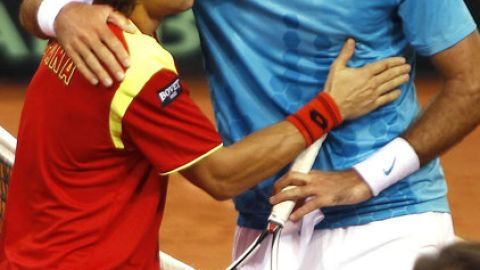 David Ferrer (izq.) trata de reanimar a un extenuado Juan Martín del Potro al final del juego maratónico en el Estadio Olímpico de Sevilla.