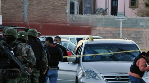 Peritos forenses investigan junto al vehículo donde el comandante de la Policía Municipal de Saltillo, capital del estado norteño de Coahuila (México), y su hijo de 11, años fueron asesinados por  sicarios.
