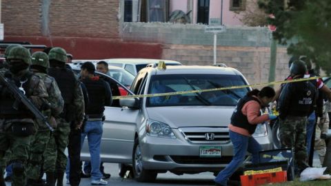 Peritos forenses investigan junto al vehículo donde el comandante de la Policía Municipal de Saltillo, capital del estado norteño de Coahuila (México), y su hijo de 11, años fueron asesinados por sicarios.