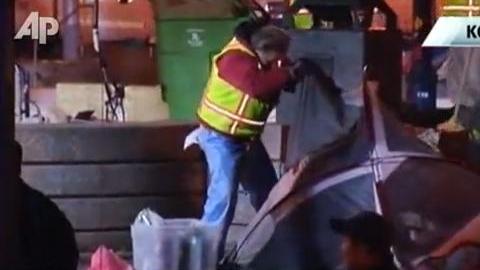 Imagen de un video transmitido en televisión muestra a trabajadores limpiando el campamento tras la redada.