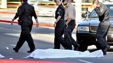 Agentes de la policía observan a su paso el cubierto cuerpo sin vida del atacante de Hollywood. Se desconocen los motivos del tiroteo.