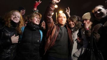 Un hombre con una máscara del primer ministro ruso Vladímir Putin protesta junto a varias personas en  San Petersburgo,  ayer.
