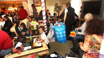 Las madres y sus pequeños reciben regalos en el evento 'Adopt a Family' del albergue Harvest Home.