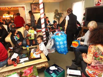 Las madres y sus pequeños reciben regalos en el evento 'Adopt a Family' del albergue Harvest Home.