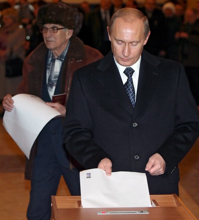 Vladimir Putin deposita su papeleta electoral en un centro de votaciones de Moscú.