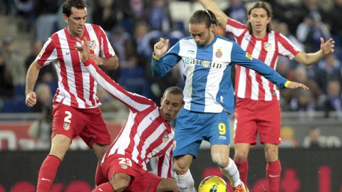 Joao Miranda, desde el suelo, intenta frenar la acción  de Sergio García (9), del Espanyol, en un trámite del partido de ayer en Barcelona
