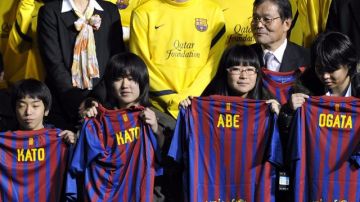 Lionel Messi (centro, atrás), muy serio, posa ayer con los pequeños que recibieron las camisetas del Barcelona con su nombre.