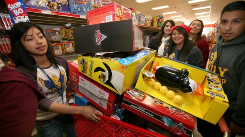 Itzel Hernandez (I), se colocaba en la fila presta para comprar juguetes para los niños y regalarlos esta Navidad.