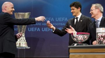 El secretario general de la UEFA, Gianni Infantino (izq), el exfutbolista rumano Miodrag Belodedici (c) y Giorgio Marchetti  durante el sorteo.