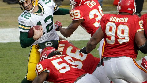 Aaron Rodgers (12) es tacleado por un grupo de defensores de Kansas City. Green Bay sufrió su primer descalabro de la temporada.