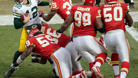 Aaron Rodgers (12) es tacleado por un grupo de defensores de Kansas City. Green Bay sufrió su primer descalabro de la temporada.