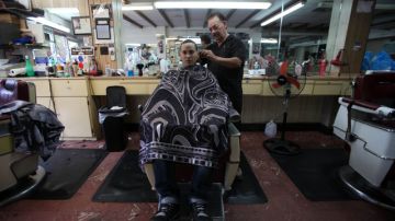 Andrés Linoa es recortado por Demetrio Ramos, propietario de la barbería 'Borinqueya' de Barrio Obrero en Santurce, cuna de la comunidad Dominicana en Puerto Rico.