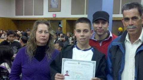 Omar Orozco, de 12 años, muestra su certificado de ciudadanía junto a sus padres  y un primo.