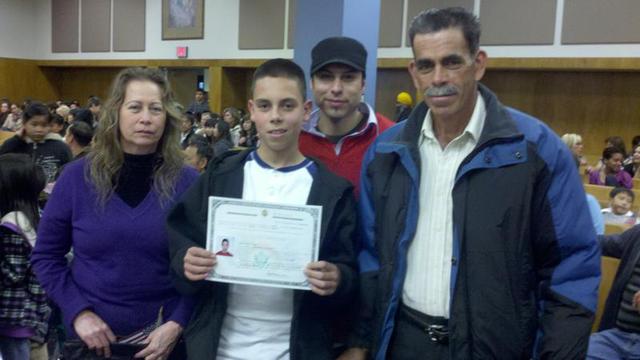Omar Orozco, de 12 años, muestra su certificado de ciudadanía junto a sus padres  y un primo.