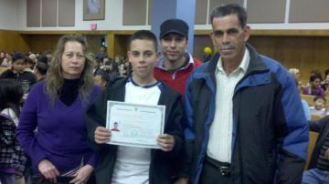 Omar Orozco, de 12 años, muestra su certificado de ciudadanía junto a sus padres  y un primo.