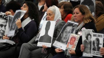 En Argentina, los familiares de desaparecidos muestran fotos de sus seres queridos.