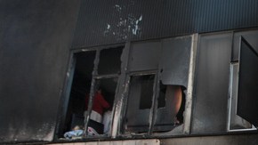 Eloísa Rentería señala hacia el lugar que sufrió daño tras el incendio en su edificio, en el bulevar North Cahuenga.