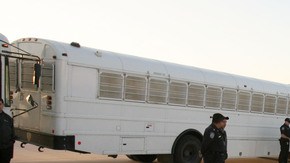 Agentes de ICE en el estado de Texas vigilan la partida de deportados, tras una detención en 2008.