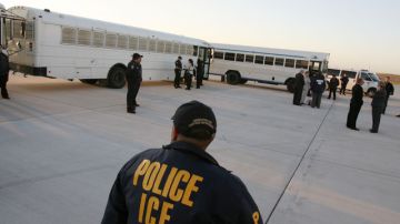 Agentes de ICE en el estado de Texas vigilan la partida de deportados, tras una detención en 2008.