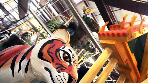 Los voluntarios ponen los toques finales a las coloridas carrozas que participarán en el Desfile de las Rosas este lunes.