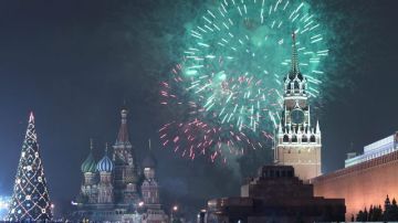 Miles de personas, como en muchos lugares del mundo, observan los fuegos artificiales,  en la Plaza Roja de Moscú (Rusia), para celebrar la llegada del Año Nuevo.