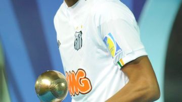 Neymar, delantero brasileño del Santos, sostiene el trofeo de balón de bronce después de que el FC Barcelona derrotara a su equipo en la final del Mundial de Clubes en el Estadio Internacional de Yokohama.