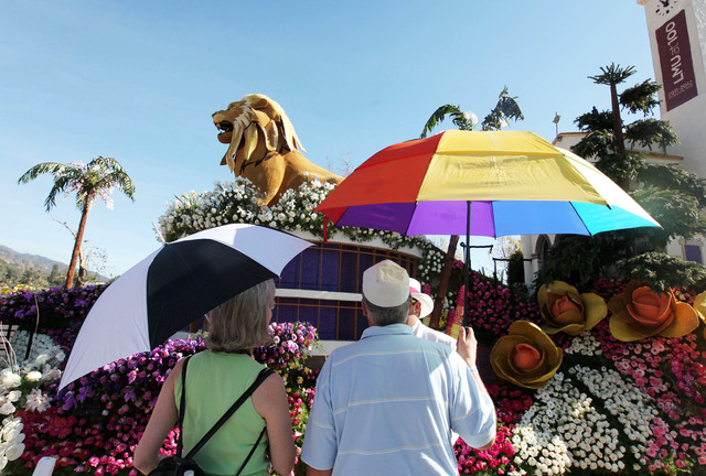 Algunos turistas que admiraban las carrozas del Desfile de las Rosas ayer llevaban sombrillas en Pasadena.