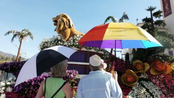 Algunos turistas que admiraban las carrozas del Desfile de las Rosas ayer llevaban sombrillas en Pasadena.