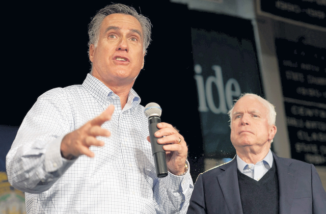 John McCain (der.) escucha al exgobernador de Massachusetts, Mitt Romney, al brindarle su respaldo tras ganar en Iowa.