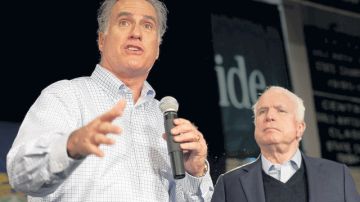 John McCain (der.) escucha al exgobernador de Massachusetts, Mitt Romney, al brindarle su respaldo tras ganar en Iowa.