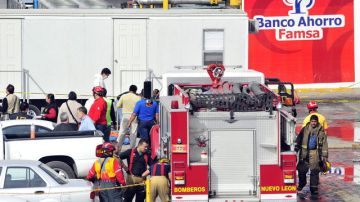 Bomberos y rescatistas trabajaban  ayer en la zona del incendio de una empresa comercial en  Monterrey.
